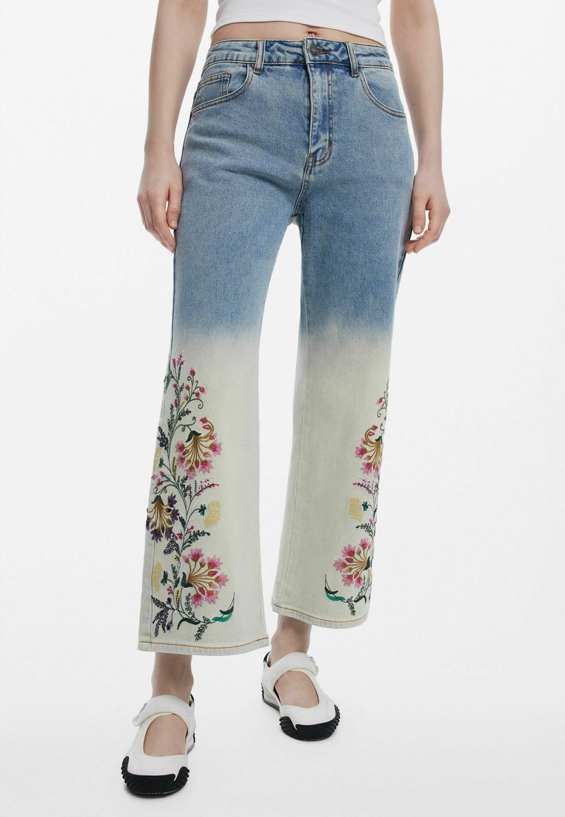 Helle blaue Denim-Hose mit weitem Bein und Ombre-Effekt, verziert mit bunten Blumenstickereien an den Unterschenkeln und klassischem fünf Taschen-Design.