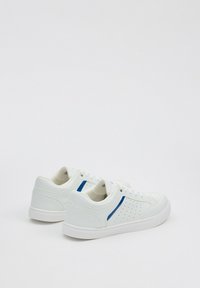 Zapatillas blancas con una textura de cuero suave, detalles perforados y una franja azul de acento en el lateral. Suelas de goma y cordones.