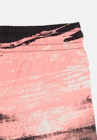 Shorts de bain roses avec une ceinture élastique noire, présentant un motif abstrait texturé dans des teintes de noir et blanc. Marque "O'Neill Hyperdry."