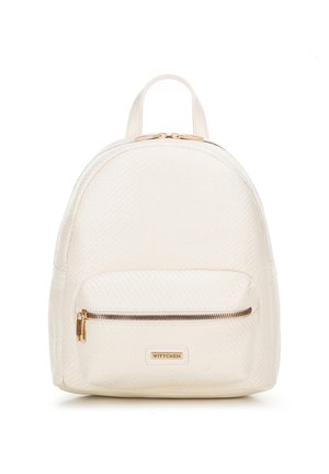 Sac à dos blanc texturé avec une forme arrondie, doté d'une poche zippée à l'avant et de détails en métal doré. Logo de la marque affiché sur une accent en cuir.