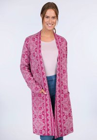 Long pink cardigan with floral patterns, open front, side pockets, and full sleeves, worn over a light top and blue jeans.