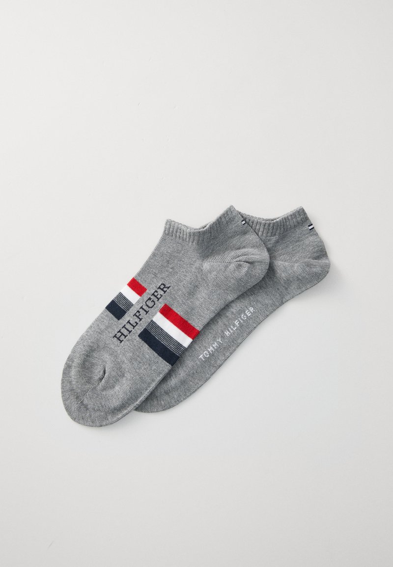 Grå ankelsockar med randigt mönster i röd, vit och marinblå, med texten "HILFIGER" och "TOMMY HILFIGER" på varje socka.