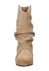 Bottine en suede beige avec un design décontracté, bout pointu et texture douce. Présente un dessus sans couture et une silhouette discrète.