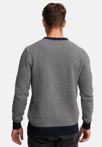 Streifenpullover in Marineblau und Weiß mit langen Ärmeln, geripptem Ausschnitt und Bündchen, strukturiertem Material, figurbetontem Design und festem marineblauen Saum.