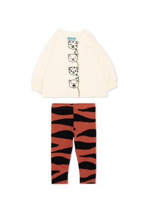 Haut à manches longues crème avec quatre visages d’animaux en contour noir sur le devant et leggings orange avec motif rayures noires de tigre.