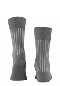 Calze grigie con righe bianche verticali, texture a coste, punte arrotondate e tallone rinforzato. Materiale morbido e lunghezza fino al polpaccio.