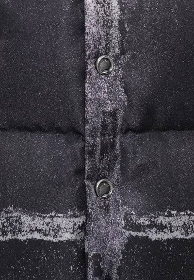 Tejido de chaqueta tipo puffer negra con patrón que presenta una superficie texturizada, botones y líneas visibles en tonos contrastantes de gris y blanco.