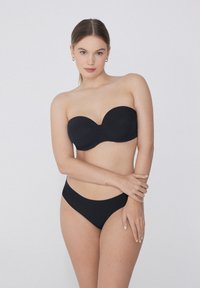 Černý bikiny top bez ramínek s hladkým povrchem, zakřivenými košíčky, doplněný o odpovídající nízké bikiny spodní. Jednoduchý, minimalistický design.