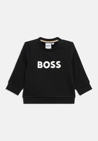 Crna majica od pamuka, s dugim rukavima i okruglim izrezom. "BOSS" logo u bijeloj boji otisnut na prednjoj strani. Detalj s kopčom na ramenu.