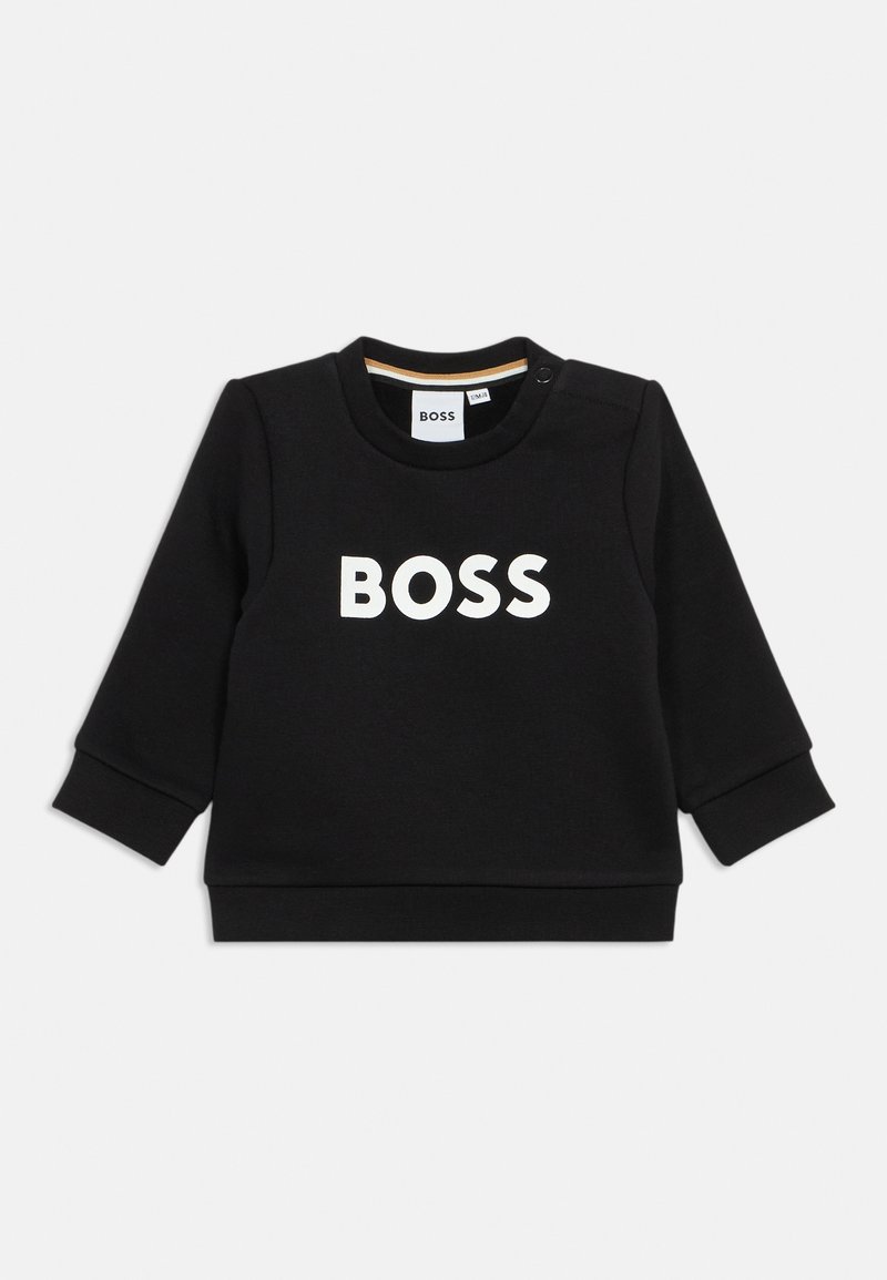 Crna majica od pamuka, s dugim rukavima i okruglim izrezom. "BOSS" logo u bijeloj boji otisnut na prednjoj strani. Detalj s kopčom na ramenu.