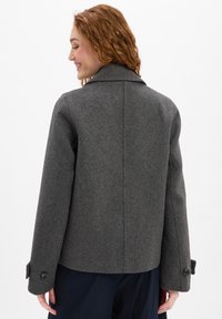 Grijze jas van een wolmix met een getailleerde pasvorm, brede kraag en manchetten met knopen. Het ontwerp met een naad aan de achterkant zorgt voor een gestructureerde vorm.