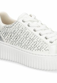 Baskets blanches ornées de cristaux sur le côté, bout arrondi, semelle plateforme plate et rainures texturées le long de la semelle extérieure.