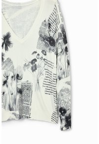 Top bianco a maniche lunghe con scollo a V, caratterizzato da stampe floreali nere e motivi di giornale. Tessuto morbido con una vestibilità leggermente ampia.