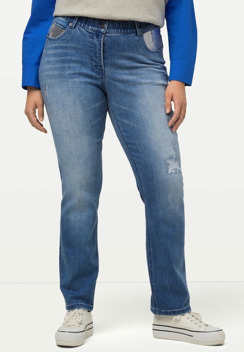 Blå denimjeans med rak benform, med lätt slitning och kontrasterande rutiga detaljer på fickorna.