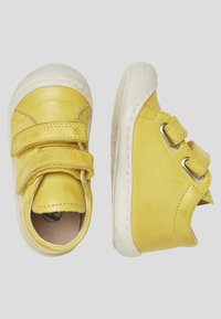 Gelbe Lederschuhe mit runder Zehenpartie, zwei Klettverschlüssen und einer weißen Gummisohle mit strukturiertem Profil.