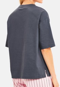 Donkergrijze short-sleeve t-shirt met een ronde hals en zijsplitten. Gemaakt van zachte stof met een gladde textuur.