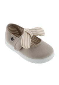 Zapato de lona beige con suela blanca, adornado con un lazo a rayas en la parte superior. El interior tiene un forro a rayas en beige y blanco.