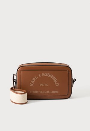Brun rektangulær crossbody taske med beige stofrem og "KARL LAGERFELD PARIS 21 RUE ST-GUILLAUME" trykt på forlomma.