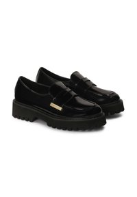 Zwarte gepatineerde leren loafers met een dikke zwarte rubberen zool, voorzien van een voorband en een klein gouden accentplaatje. Glad, glanzende afwerking.