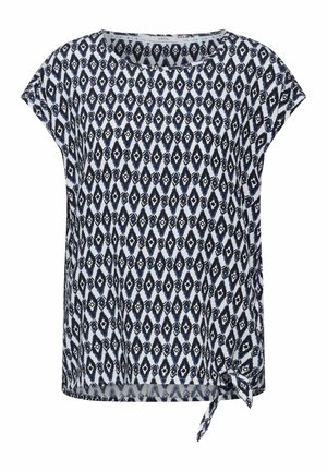 Korte mouwen, losse top gemaakt van lichtgewicht stof. Heeft een marineblauw en witte ruitpatroon met een gestrikt accent aan de zoom.
