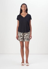 Black V-neck t-shirt with short sleeves, paired with beige shorts featuring a black leopard print. Simple slide sandals complete the outfit.