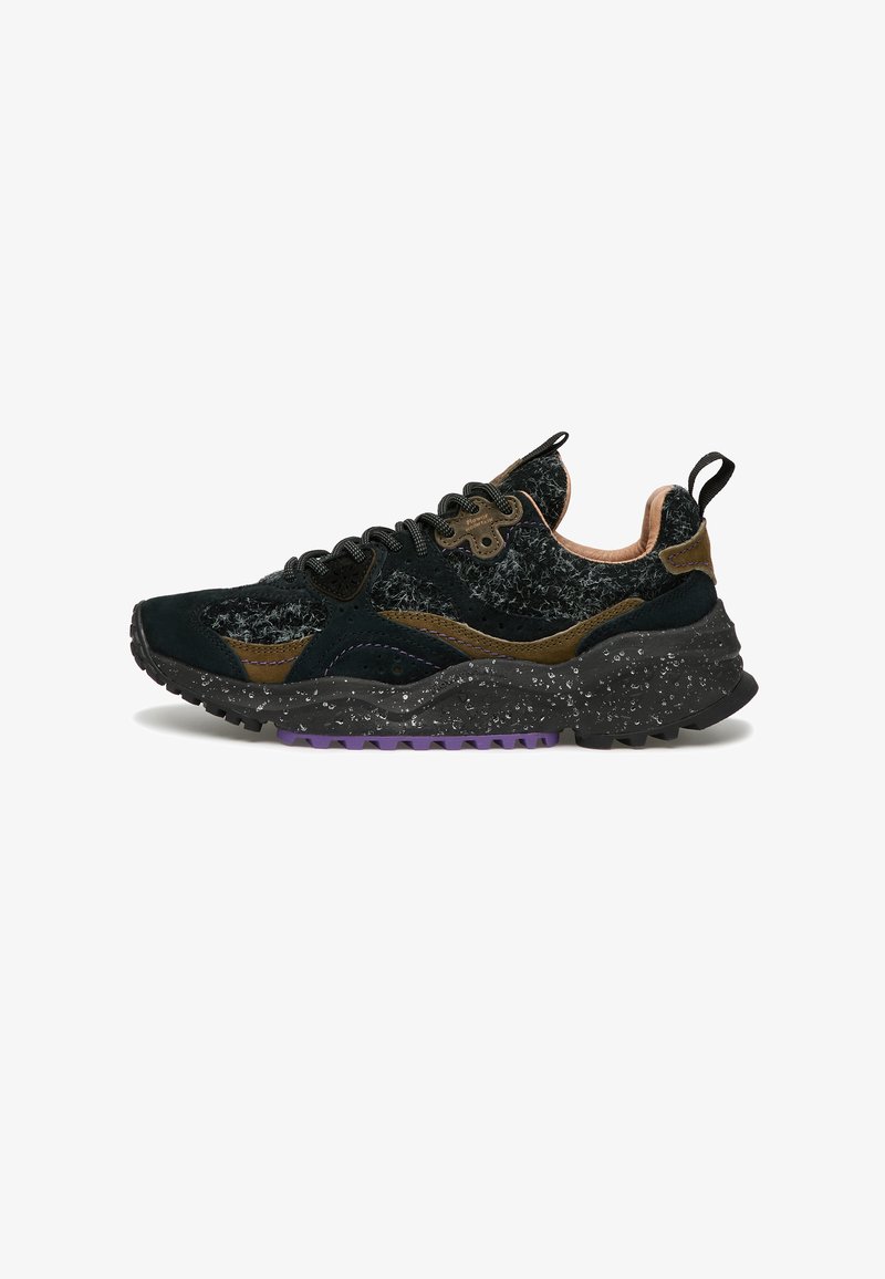 Scarpa sportiva nera e marrone con tomaia in tessuto texture, suola nera maculata, battistrada viola, linguette di trazione e allacciatura a sei occhielli.