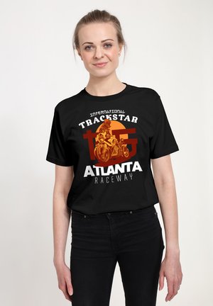 Schwarzes Baumwoll-T-Shirt mit fett gedrucktem weißen und orangenen grafischen Text: "International Trackstar Atlanta Raceway", mit einer Motorradillustration.