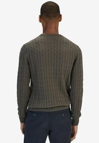 Groene kabelgebreide trui met een ronde halslijn en geribbelde manchetten, voorzien van gestructureerde stiksels en een aansluitende pasvorm.