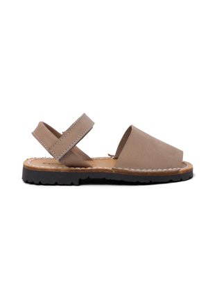 Sandal de punta abierta en cuero marrón claro con suela plana de goma negra. Presenta dos correas ajustables y acentos de costura visibles.