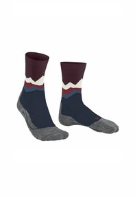 Calzini con un design a montagne multicolore, con tonalità di blu scuro e marrone bordeaux e una suola grigia, esposti uno accanto all'altro.