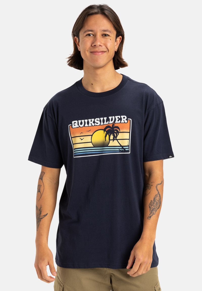 Camiseta de algodón azul marino con un estampado gráfico que incluye un sol, palmeras y rayas horizontales en naranja, amarillo y azul. Manga corta.
