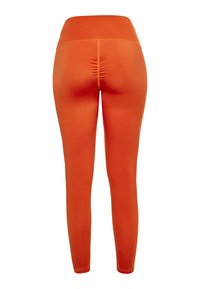 Oranžové legíny s hladkým texturem, vysokým pasem a nařasením na zadní straně. Přiléhavý design sahající až k ankám.