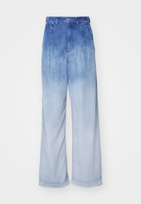 Δαγκωτά τζιν παντελόνια με μπλε γραδίαντ, που μεταβαίνει από σκούρο στο πάνω μέρος σε ανοιχτό στο κάτω. Φτιαγμένα από τζιν με ορατή υφή.