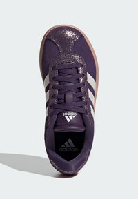 Scarpa sportiva viola con strisce bianche; parte superiore con finitura metallica testurizzata; suola in gomma; design con lacci; marchio sulla linguetta e nella soletta.