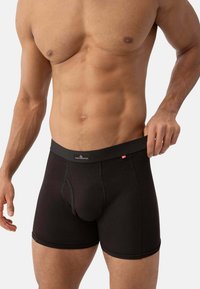 Zwarte boxershorts voor heren met een brede elastische tailleband, voorzien van een contoured pouch, een gladde textuur en platte naden voor comfort.