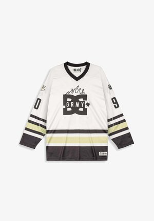 Wit hockeyshirt met lange mouwen met zwarte en gele strepen, een zwarte kraag, vlammenontwerp boven het "DC GRMY"-logo en de nummers "0" en "9" op de mouwen.