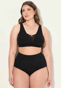 Conjunto de lencería negra que incluye un sujetador sin aros con detalles de encaje y una parte inferior de cintura alta. Material suave y elástico con una textura lisa.