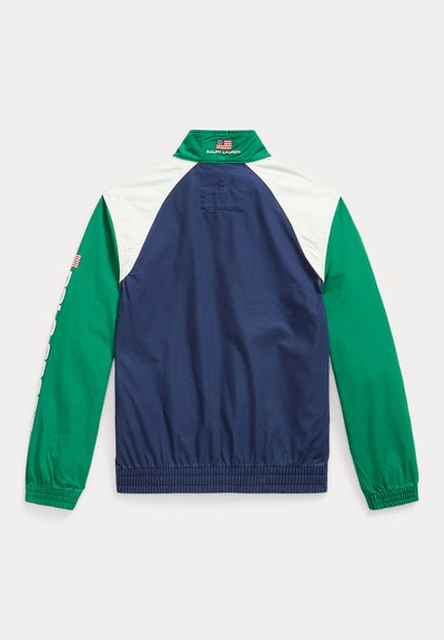 Ναυτικό μπλε μπουφάν με πράσινες και λευκές λεπτομέρειες, διαθέτοντας ελαστικές μανσέτες και ζώνη, καθώς και ένα μικρό λογότυπο στο μανίκι. Εμφανίζεται η πίσω όψη.