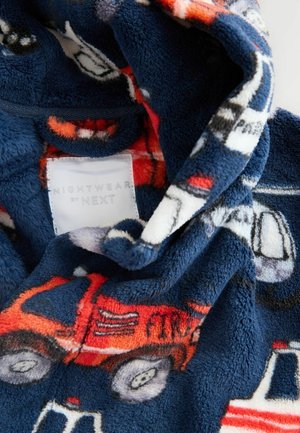 Pyjama en polaire avec une base marine ornée de motifs de véhicules colorés, comprenant des camions orange et des voitures grises, avec une texture douce.