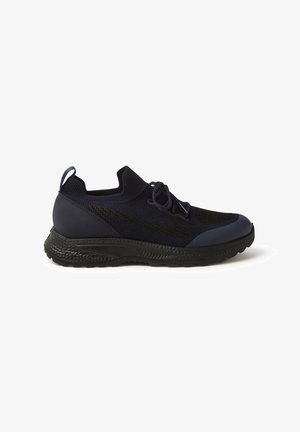 Navy blue athletic shoes with a knit upper, textured black midsole, and a rounded toe. Features laces and a pull tab on the heel.