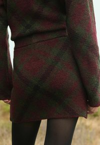 Wollmischung Pullover-Set in dunkelrotem und grünem Karomuster, mit langen Ärmeln und einem enganliegenden Rock mit geradem Saum. Glatte Textur.