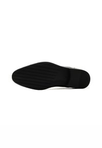 Suola di scarpa in gomma nera con forma curva, caratterizzata da scanalature orizzontali per la trazione e una finitura liscia sul tallone.
