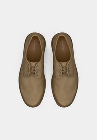 Pair of light brown leather lace-up casual shoes viewed from above on white background.
