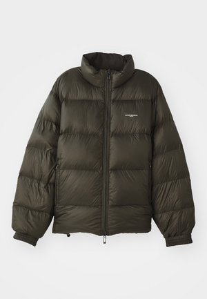 Manteau rembourré vert foncé avec un col haut, fermeture éclair, poignets élastiques et poches latérales. Présente une texture matelassée et un branding minimal.