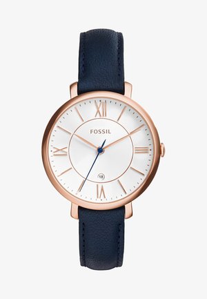 Montre Fossil avec un cadran texturé blanc, un boîtier en or rose, des chiffres romains et un bracelet en cuir bleu foncé. Dispose d'une fenêtre de date à 6 heures.
