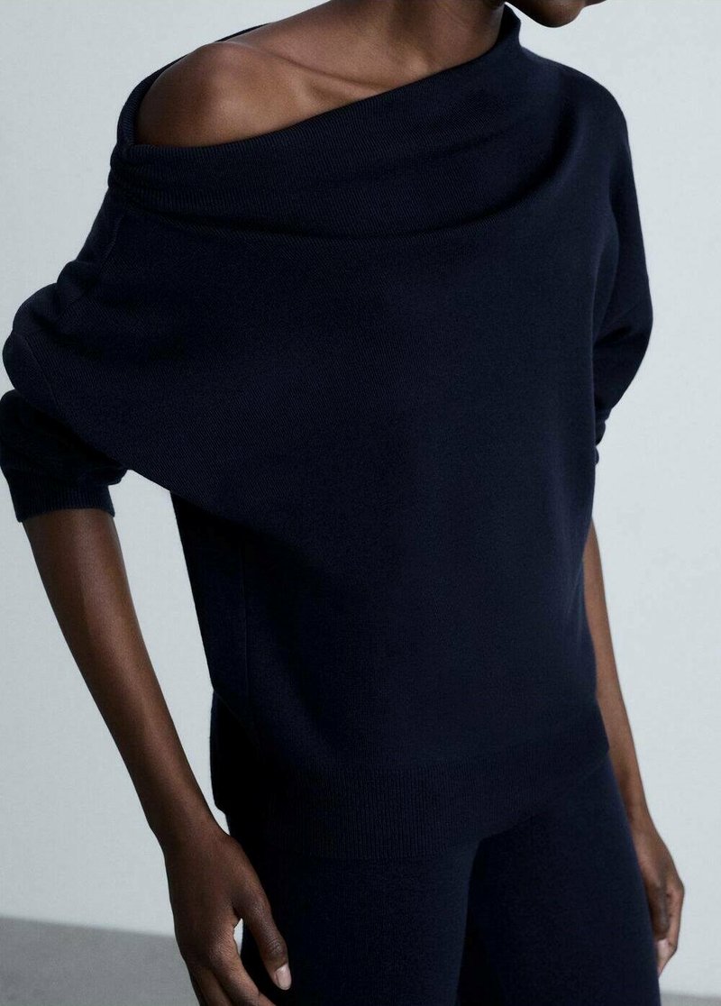 Maglione navy a spalle scoperte in morbido filato con vestibilità rilassata e ampio scollo a barca, caratterizzato da maniche lunghe e bordo a coste.