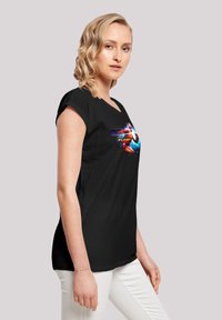 Black short-sleeve t-shirt featuring a colorful graphic of a superhero in motion with the word "FLASH" beneath it. Smooth fabric texture.