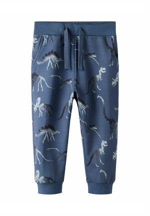 Modré nohavice pre batoľa s rebrovaným pásom a lemami, s potlačou bielych a tmavých kostier dinosaurov a prednými vreckami s šnúrkou na stiahnutie.