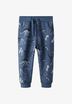Modre otroške hlače z rebrastim pasom in manšetami, z belimi in temnimi odtisi dinozavrovih okostij ter sprednjimi žepi z zavezovanjem.