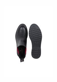 Czarne skórzane buty na slip-on z gładką cholewką i kontrastowym, czerwonym wykończeniem; gumowa podeszwa z wzorem bieżnika. Zawiera materiałową pętelkę do zakładania.